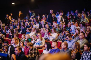 Valmiera, Letonya - 28 Aralık 2023 - çeşitli seyirciler bir tiyatroda oturmuş, bir etkinliğin başlamasını bekliyorlardı.