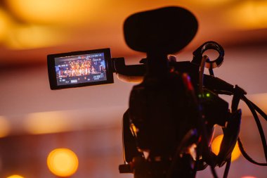 Valmiera, Letonya - 28 Aralık 2023 - sıcak sahne aydınlatmalı bir sahne performansını gösteren bir video kamera LCD ekranının yakın çekimi.