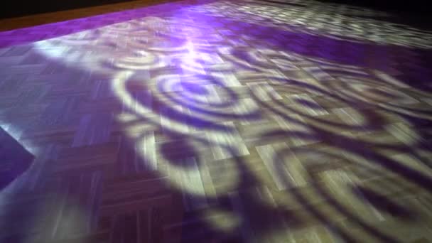 紫色のライトおよび影のパターンが付いているパーケットの床 ステンドグラスの窓か着色された光源からの可能性が高い — ストック動画