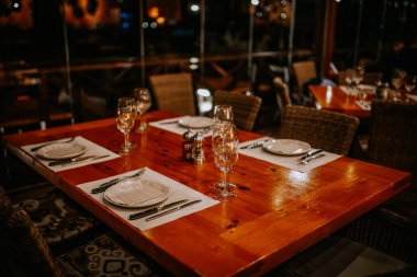 Malaga, İspanya - 21 Ocak 2024 - Sıcak bir restoranda yemek masası için hazırlanan cam tabaklar ve peçeteler.