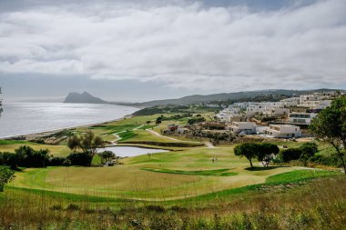 Sotogrande, İspanya - 23 Ocak 2024 - Cebelitarık Kayası ile denize bakan bir golf sahası.