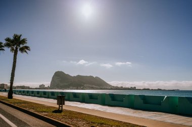 Santa Margarita, İspanya - 24 Ocak 2024 - Cebelitarık 'ın ikonik Kayası, açık ve güneşli bir gökyüzünün altında deniz kenarında gezinti alanı.