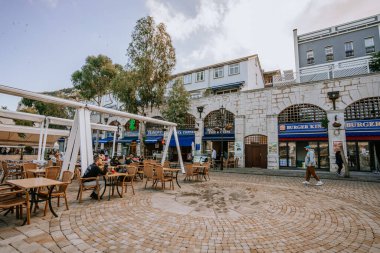 Cebelitarık, İngiltere - 24 Ocak 2024 - patronlar, Burger King mağazası ve Cebelitarık 'taki kaldırım taşı plazadaki diğer dükkanlarla birlikte açık hava yemek alanı..