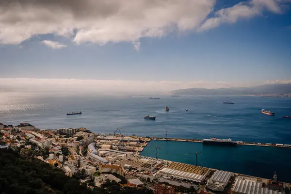 Gibraltar, Britain - January 24, 2024 - vast view of the sea with multiple ships near Gibraltar, the city, and a distant mountain range.