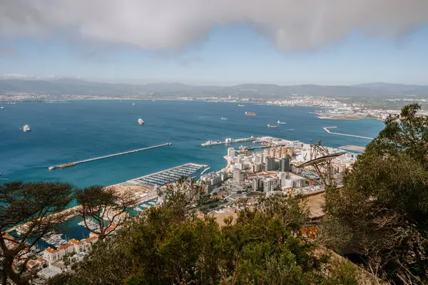 Gibraltar, Britain - January 24, 2024 - expansive view of Gibraltar, showcasing the port, densely packed buildings, and the bay against a mountain backdrop.