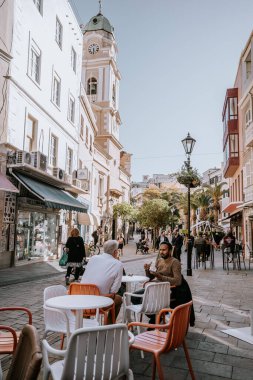 Cebelitarık, İngiltere - 24 Ocak 2024 - Kafe masalarında insanlar, bir saat kulesi ve açık bir gökyüzü.