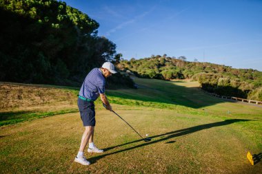 Sotogrante, İspanya - 25 Ocak 2024 - Adam golf sahasında ağaçlarla ve açık gökyüzüyle sallanıyor.