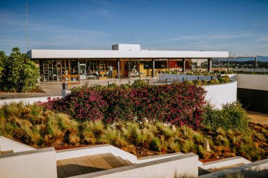 Sotogrante, İspanya - 25 Ocak 2024 - Modern bina, büyük pencereler, açık oturma, çiçekler, çimenler, basamaklar, temiz gökyüzü.