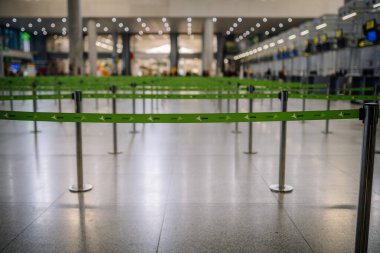 Malaga, İspanya - 28 Ocak 2024 - Havaalanı kayıt alanındaki bariyer bantları boş, bulanık arka plan, duruş, zemin yansımaları.