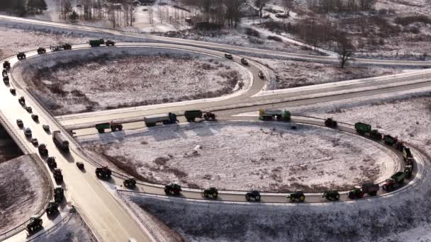 拉脱维亚瓦尔米耶拉 2024年1月5日 在一个乡村风景区的雪地路上 空中看到了一个环路和一队拖拉机 农民抗议车队 — 图库视频影像