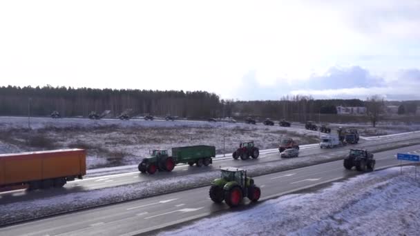 2024年2月5日 曇った空の下の雪の道のトラクターとトラックのキャラバン 農民は政府の決定に抗議 — ストック動画