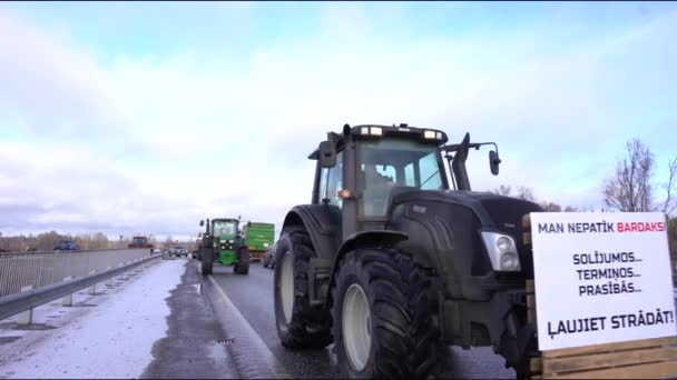 2024年2月5日 曇った空の下の雪の道のトラクターとトラックのキャラバン 農民は政府の決定に抗議 — ストック動画