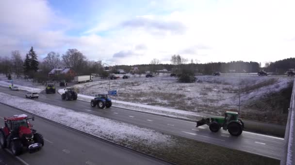 拉脱维亚瓦尔米拉 2024年2月5日 在多云的天空下 一辆由拖拉机和卡车组成的大篷车在雪地的路上 农民抗议政府的决定 — 图库视频影像