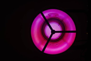 Valmiera, Letonya - 7 Temmuz 2023 - Yuvarlak, mor neon ışıklı yakın plan.