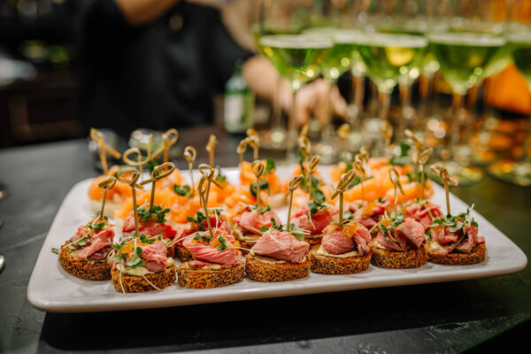 Riga, Latvia - January 18, 2024 - Canapes on a white plate with blurred background, catering at an event.