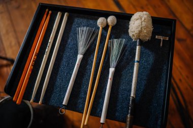 Valmiera, Letonya - 7 Ocak 2024 - Saint Simon Kilisesi. Ahşap bir zeminde mavi keçeli bir tepsi üzerinde baget ve tokmak koleksiyonu..