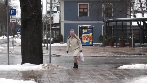 拉托维亚Sigulda 2024年2月13日 一个人在湿滑的街道上走着 走着雪 路过一个停车标志和一辆模糊的汽车 — 图库视频影像