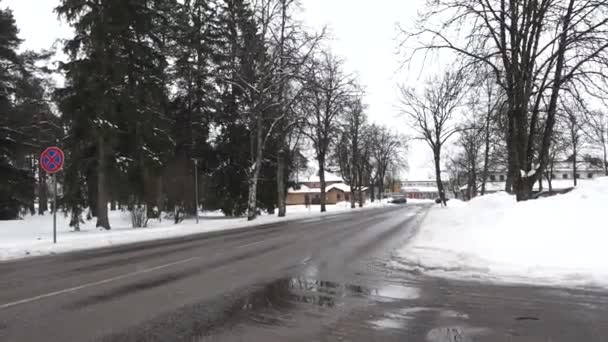 2024年2月13日 ラトビアのシグルダ 駐車場の標識 雪に覆われた歩道 遠くにある建物のない湿った都市道路 — ストック動画
