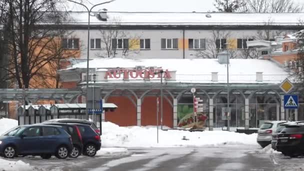 ラトビアのシグルダ 2024年2月13日 Autoosta サイン 駐車場 歩行者横断 雪の積み重ねを備えたバスステーション — ストック動画