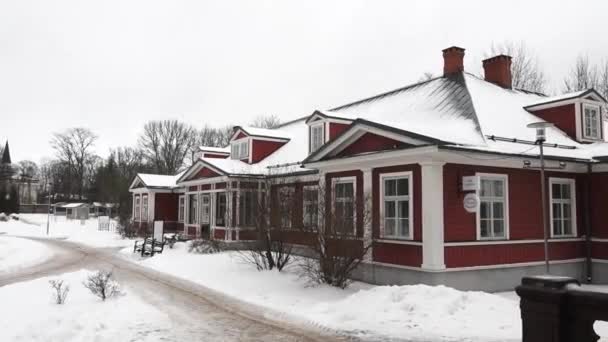 拉脱维亚Sigulda 2024年2月13日 白色装饰的红木房子 雪地覆盖的屋顶 以及雪地中的多个烟囱 树木光秃秃 — 图库视频影像