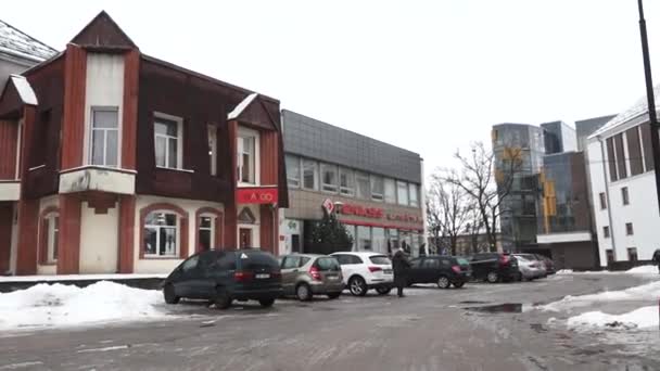 セシス ラトビア 2024年2月13日 古い建造物と新しい建築の混合された市街地の景色 建物の前に駐車された車 地面に雪のパッチ そして曇った空 — ストック動画