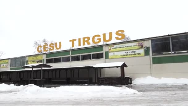 塞西斯 拉脱维亚 2024年2月13日 一座标有 Cesu Tirgus 标志的市场建筑 表明它是塞西斯市场 地面上有雪 前面有一片市场 — 图库视频影像