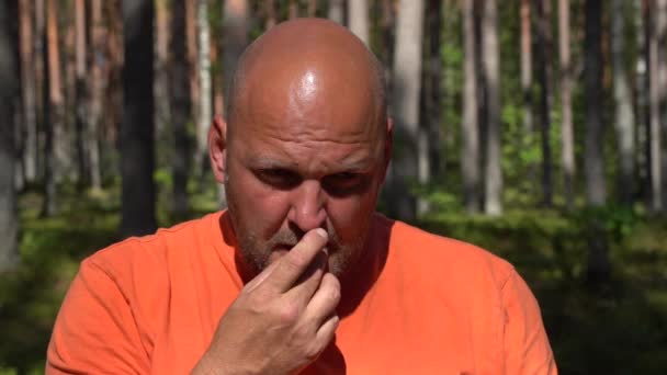 穿着橙色衬衫的男人在森林里品酒或吃蓝莓 — 图库视频影像