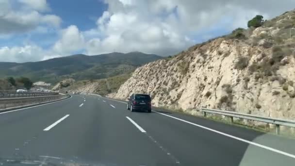 西班牙索托格朗德 2024年1月22日 多车道高速公路上一个晴朗的一天 一边是悬崖面 另一边是山区背景下的一行车辆 驾驶汽车 — 图库视频影像