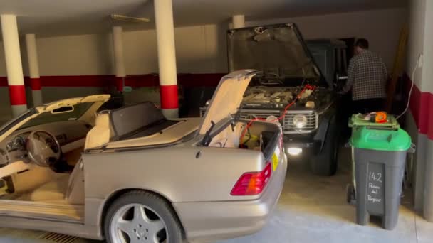 西班牙索托格朗德 2024年1月22日 两辆汽车停放在车库里 其中一辆敞着车篷 与充电器相连 — 图库视频影像