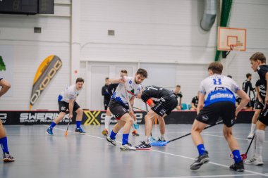 Valmiera, Letonya - 17 Şubat 2024 - bir oyuncu ve çevresindeki diğer oyuncularla birlikte bir oyun veya antrenman sırasında florbol oyuncuları hareket halindedir..