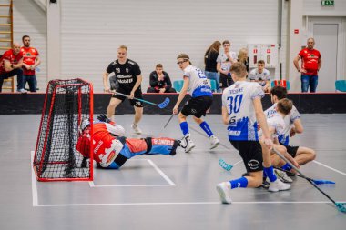 Valmiera, Letonya - 17 Şubat 2024 - Oyuncuların gol yakınlarında hareket halinde olduğu bir an, bir kaleci kurtarmak için dalıyor