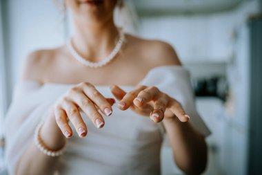 Riga, Letonya - 20 Ocak 2024 - Nikah yüzüğü takıyor gibi görünen bir gelinin yakın çekimi. Tırnakları Fransız uçlarıyla kaplanmış..