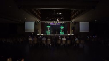 Agadir, Fas - 25 Şubat 2024 - Seyirciler mavi ışık ve duman efektli bir sahne performansı izliyorlar.