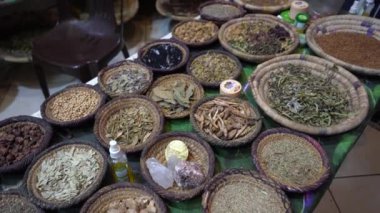 Agadir, Fas - 25 Şubat 2024 - Arkadaki plastik sandalyeyle örülmüş sepetlerdeki kurutulmuş ot ve baharatlar.