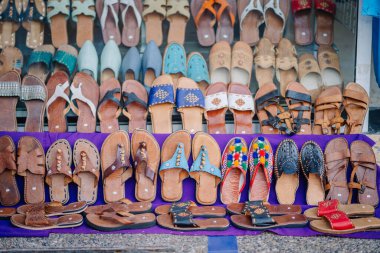 Agadir, Fas - 25 Şubat 2024 - Sokak pazarında çeşitli sandaletler sergileniyor.