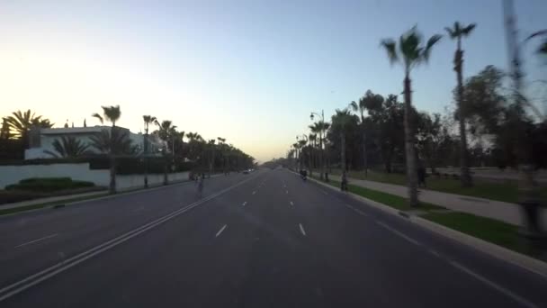 摩洛哥阿加德德 2024年2月27日 在黄昏或黎明时分 从公共汽车上看到一条由建筑物和棕榈树侧边的空旷街道 — 图库视频影像
