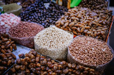 Agadir, Fas - 29 Şubat 2024 - Çeşitli fasulye ve tarihler bir market tezgahında geniş açık çantalarda sergilenir..