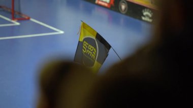 Valmiera, Letonya, 10 Mart 2024 - Siyah ve sarı renkli bir bayrak ve merkezinde kalın, dairesel bir logo sallanıyor. 