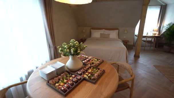 セシス ラトビア 2024年2月14日 木製の家具付きの部屋にベージュカバーと白い枕ときちんと作られたベッド ヘリンボーンフロア ウィンドウのライティングデスク — ストック動画