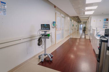 Valmiera, Letonya - 20 Mart 2024 - Hastane koridoru, seyyar stanttaki hayati göstergeler, panjurlu kapı pencereleri, bilgilendirici posterler, el dezenfektanı, elektrik prizleri, uyarı levhaları, döşeme döşemeleri,.