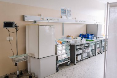 Valmiera, Letonya - 20 Mart 2024 - Donanım, buzdolabı, malzeme depolama üniteleri ve kan basıncı monitörü olan bir tıbbi hazırlık alanı.