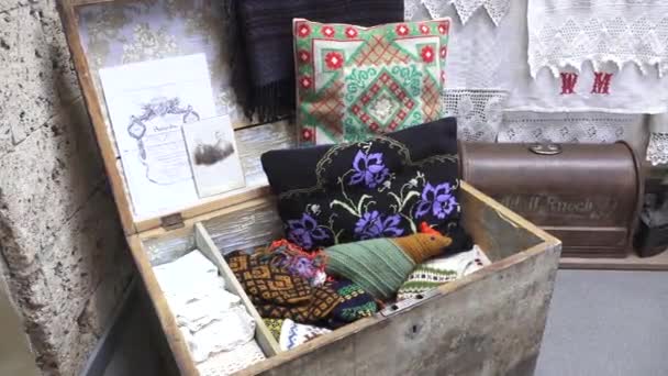 拉脱维亚Incukalns 2024年3月10日 一个开放的木箱展示五彩缤纷的针织纺织品 绿色绣花枕头 以及石墙上的老式照片 — 图库视频影像