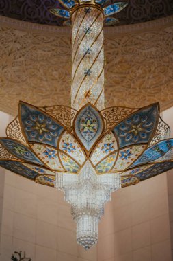 Dubai, Birleşik Arap Emirlikleri - 19 Ekim 2019 - Detaylı bir tavandan sarkan, kristal bir süs ve ayrıntılı taç yaprağı tasarımı ile süslü bir avize.