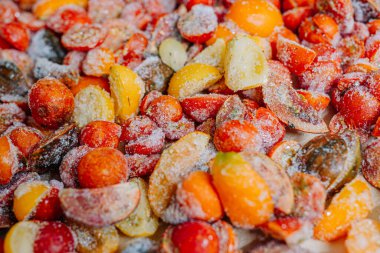 Buz kristalli buz gibi domatesler, kırmızı ve sarı renklerin karışımı..