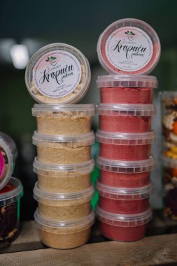 Valmiera, Letonya - 27 Mart 2024 - Yabancı bir dilde etiketlenmiş, muhtemelen kurutulmuş meyve tozu içeren bej ve kırmızı tozlu konteynırlar.