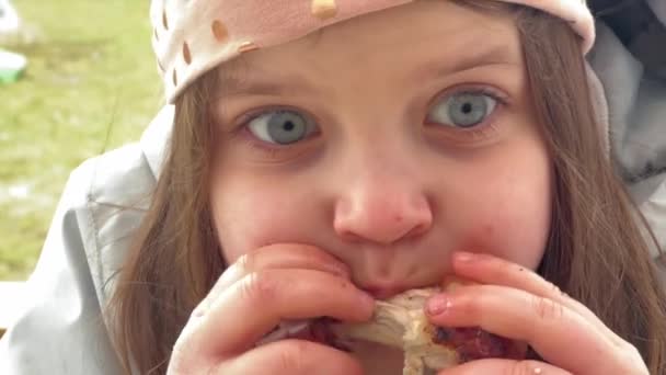 Közelkép Egy Fiatal Lányról Kék Szemekkel Amint Egy Csirkeszárnyat Eszik — Stock videók