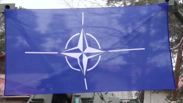Natoの旗は木が付いている軍事基地のクレーンに表示され 背景に建物 — ストック動画