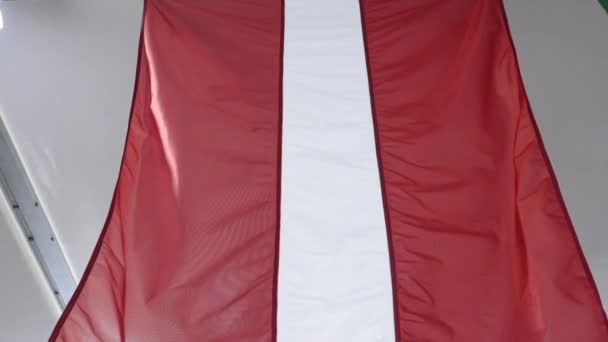 拉托维亚阿达齐 2024年4月4日 北约75周年庆典在阿达齐军事基地举行 悬挂在室内的红白两色旗帜的特写 拉脱维亚文 — 图库视频影像