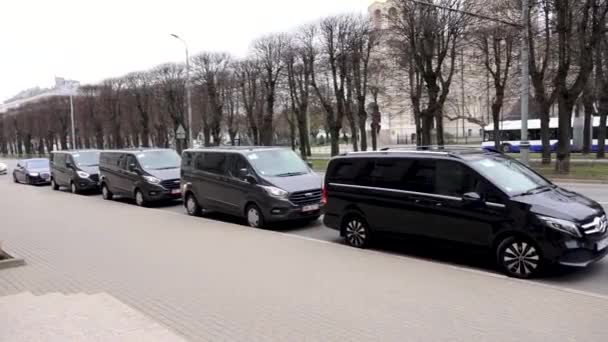 ラトビア 2024 市街地に駐車された黒いバンのライン 樹木と背景の建物 — ストック動画