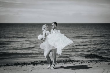 Valmiera, Letonya - 10 Ağustos 2023 - Sahilde siyah beyaz bir fotoğrafta gelin kaldırma.